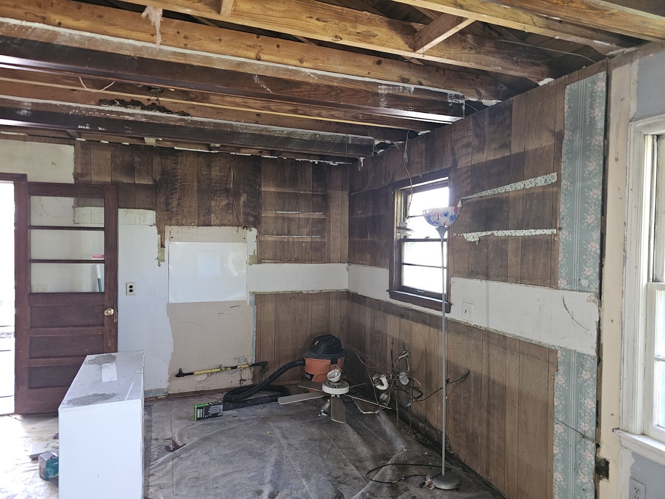 Unfinished room with exposed wood beams and flooring.